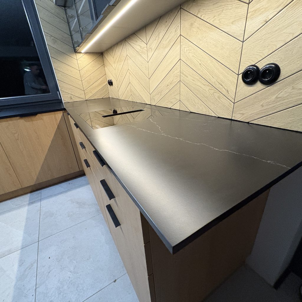 blaty kuchenne z konglomeratu nero venato w satynie - widok na blat z indukcją