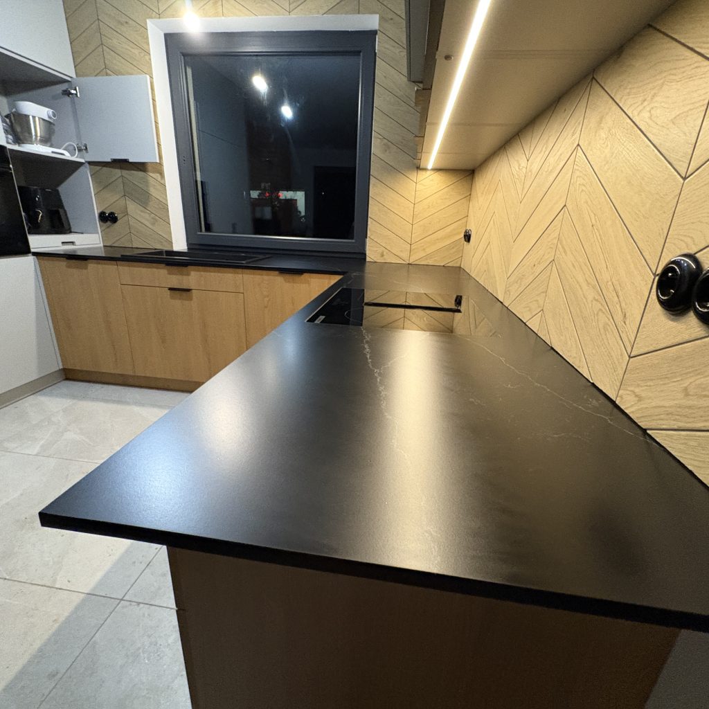 blaty kuchenne z konglomeratu nero venato w satynie - widok od strony blatu z indukcją