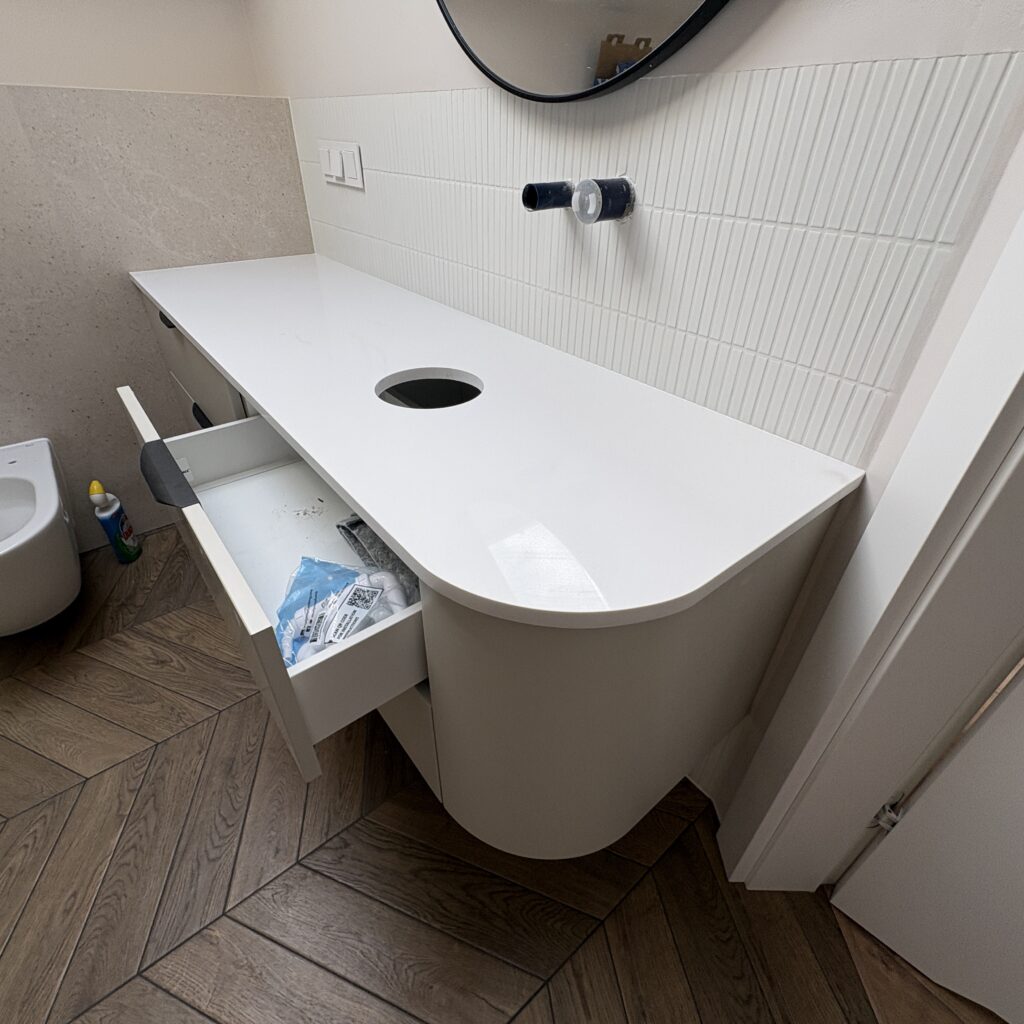 blat łazienkowy z łukiem zgodnie z linią mebla z konglomeratu Polar White - widok z prawej