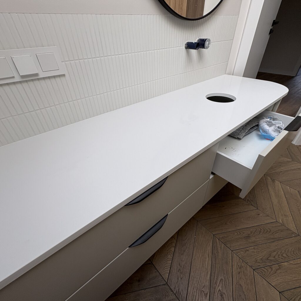 blat łazienkowy z łukiem zgodnie z linią mebla z konglomeratu Polar White - widok z lewej