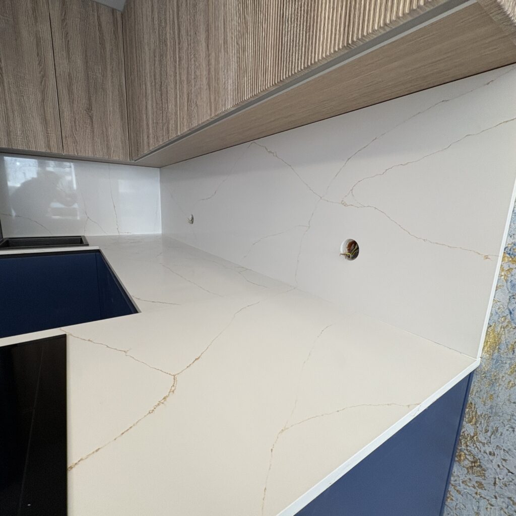 blaty i okładziny z konglomeratu Calacatta Gold -widok na blat i okładzinę z prawej strony