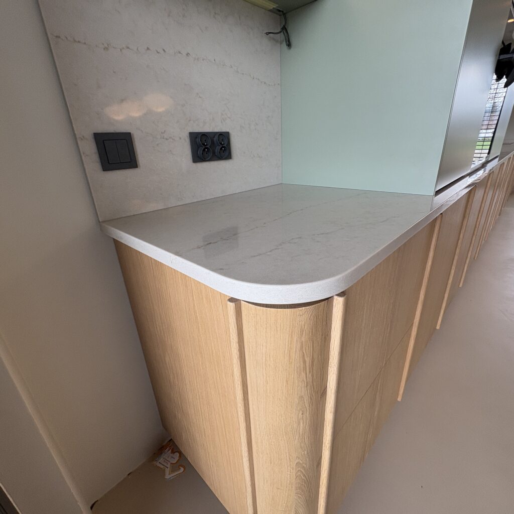 kuchnia wykończona blatami Taj Mahal Gold 3cm - wiadok na pierwszy blat roboczy z zaoblonym narożnikiem zgodnie z linią mebli