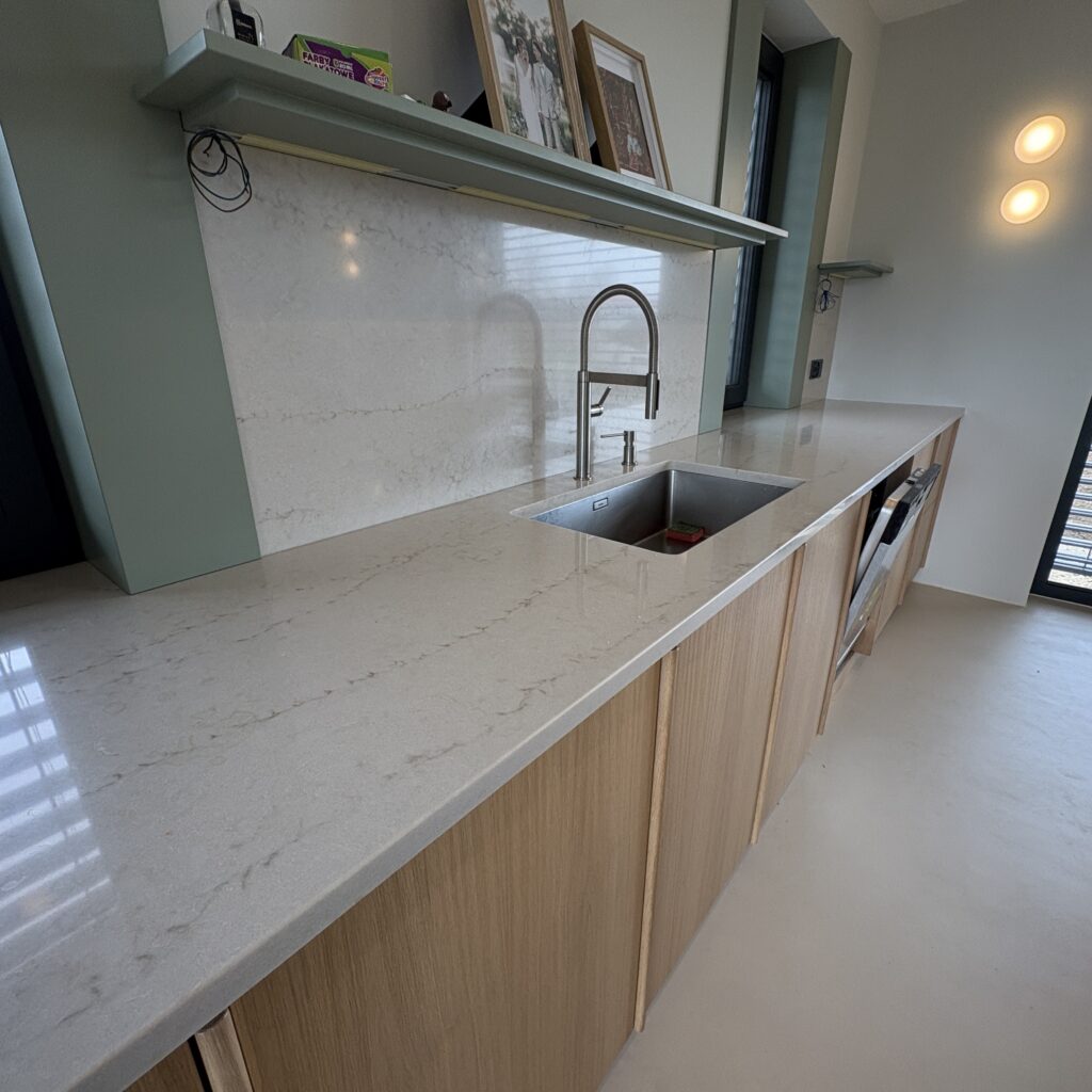 kuchnia wykończona blatami Taj Mahal Gold 3cm - wiadok na blat ze zlewem podwieszanym