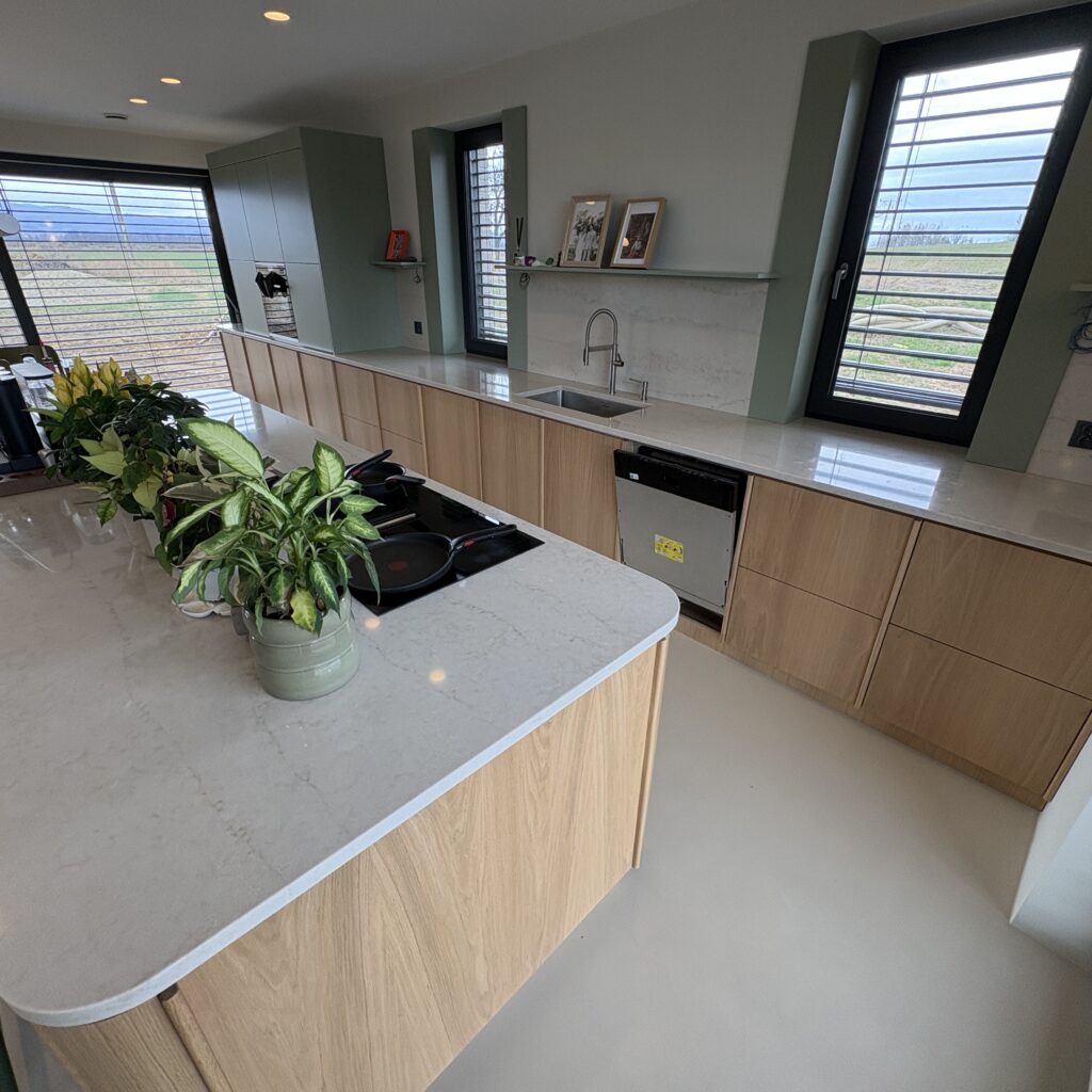 kuchnia wykończona blatami Taj Mahal Gold 3cm - wiadok na wyspę i blaty robocze z prawej strony