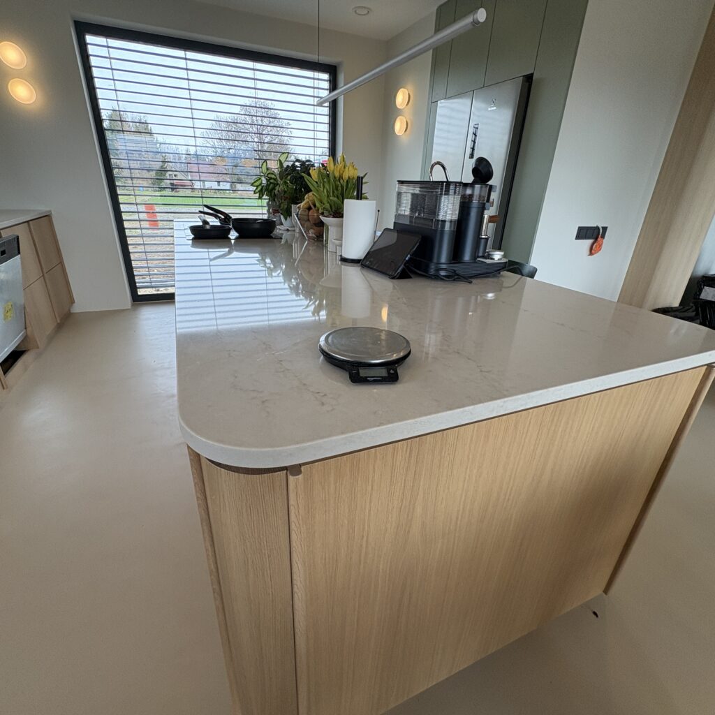 kuchnia wykończona blatami Taj Mahal Gold 3cm - wiadok na wyspę z lewej strony