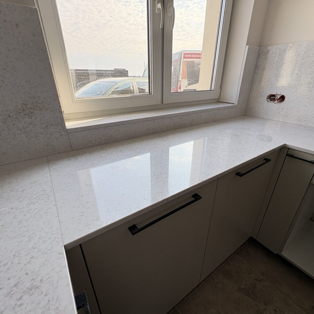 blaty kuchenne i okładziny z konglomeratu Wedding Lily - widok na blat pod oknem i parapet