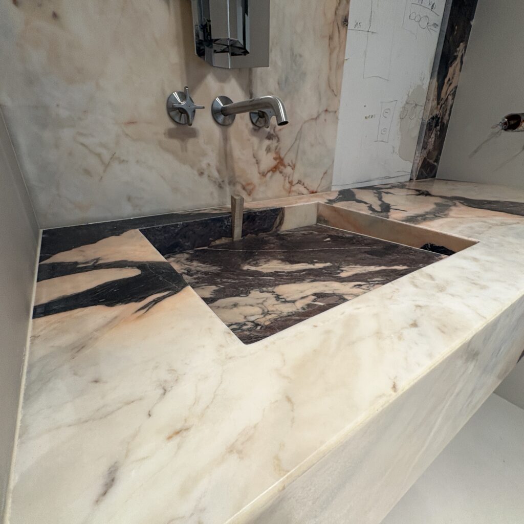 blat łazienkowy z umywalką zintegrowaną oraz okładziny ścienne z marmuru Calacatta Nobile - widok z lewej strony