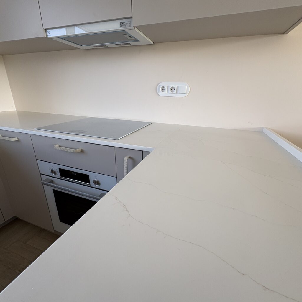 blaty z konglomeratu Calacatta Cannes Gold - widok na łączenie blatu z indukcją z blatem wyspy