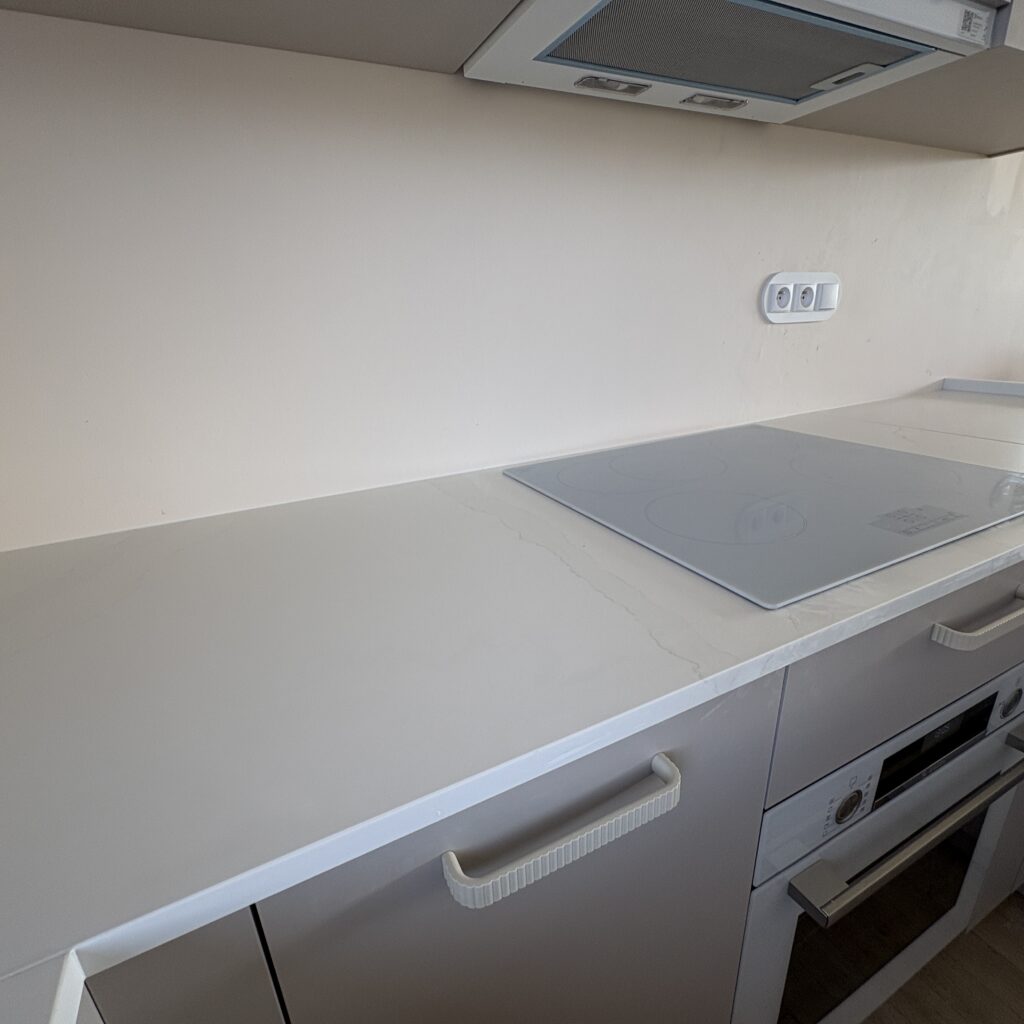 blaty z konglomeratu Calacatta Cannes Gold - widok na blat z indukcją