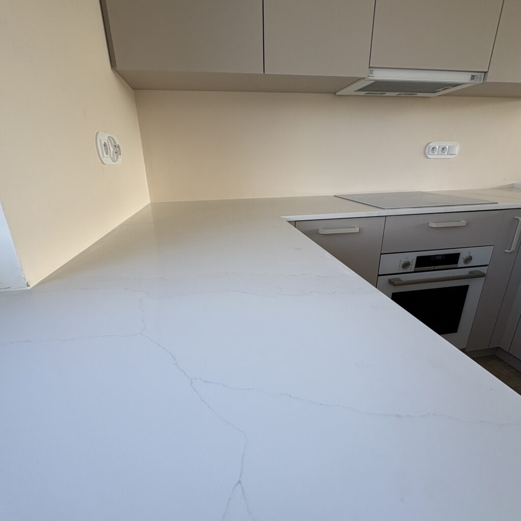 blaty z konglomeratu Calacatta Cannes Gold - widok na łączenie blatów oraz indukcję