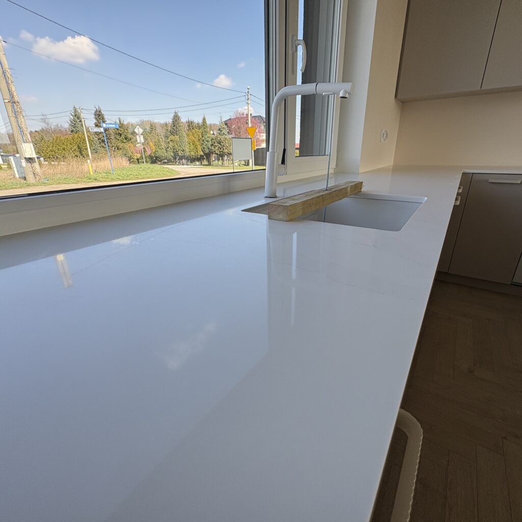 blaty z konglomeratu Calacatta Cannes Gold - widok na zlew podwieszany z powierzchni blatu